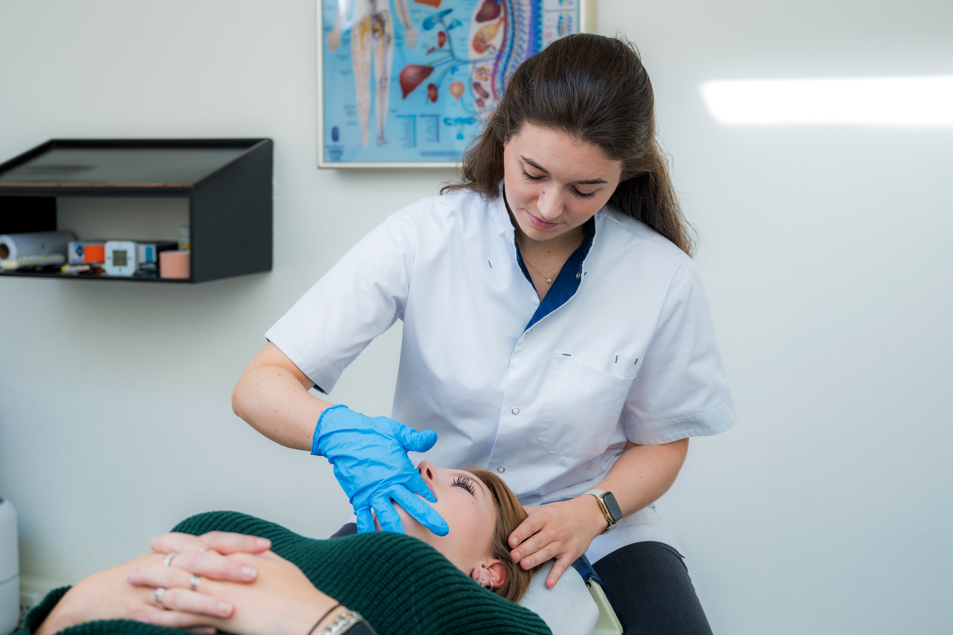 Vrouw met kaakpijn wordt behandeld door chiropractor