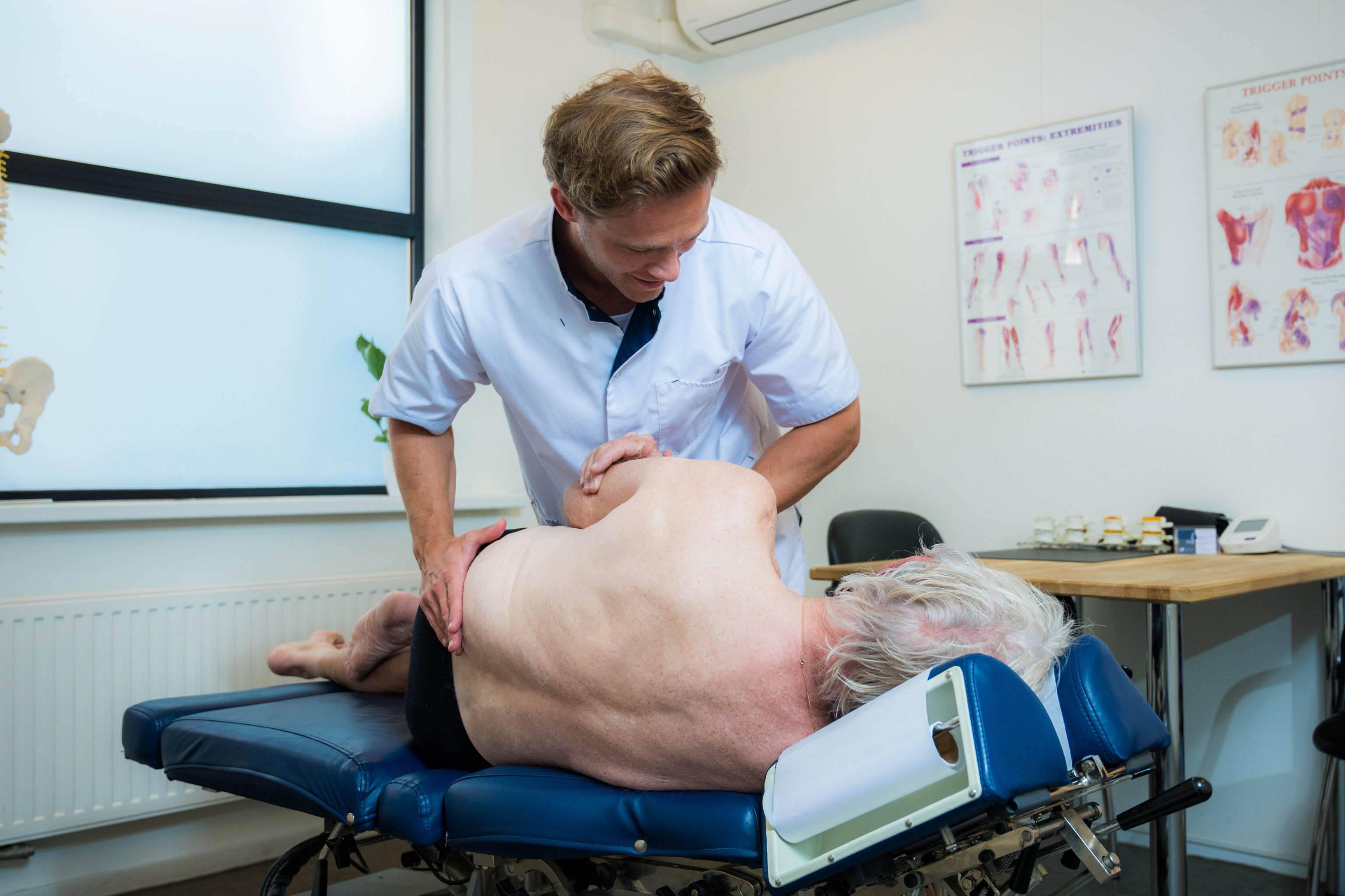 Oudere met spit wordt behandeld door chiropractor